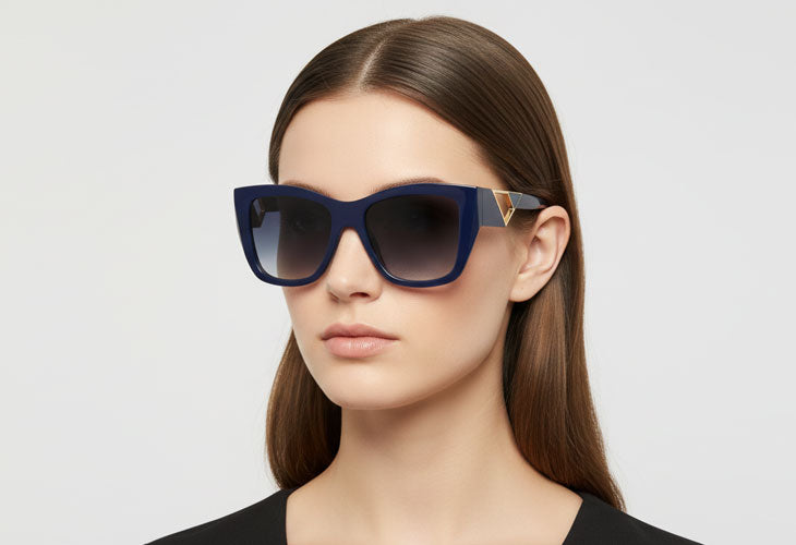 Woman wearing blue sunglasses with a neutral background