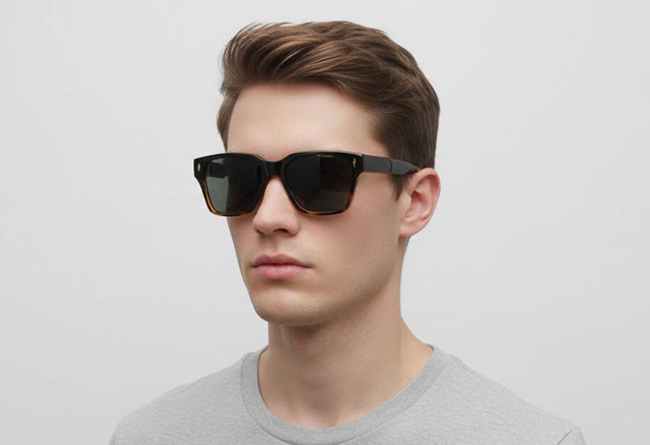 Man wearing black sunglasses against a plain background