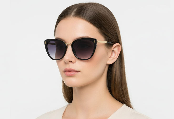 Woman wearing a pair of cat-eye sunglasses with a plain background