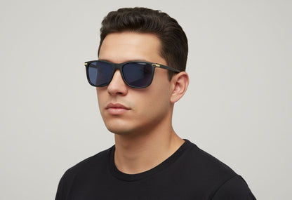 Man wearing dark sunglasses and a black shirt against a light gray background
