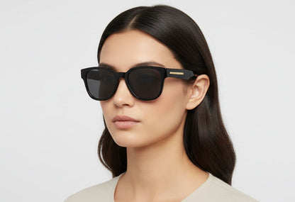 Woman wearing dark sunglasses with a neutral background