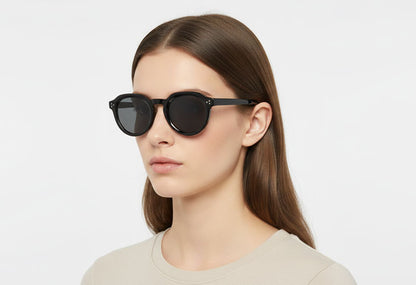 Woman wearing black sunglasses against a white background