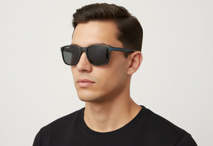 Man wearing black sunglasses against a light gray background