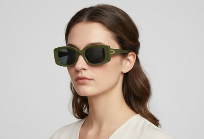Woman wearing green sunglasses against a plain background