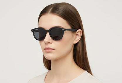 Woman wearing black sunglasses against a plain background