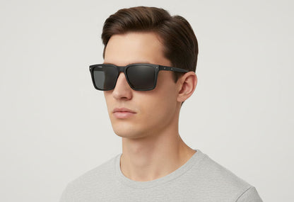 Man wearing black sunglasses against a light gray background