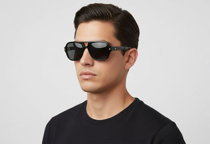 Man wearing black sunglasses and a black shirt against a light gray background