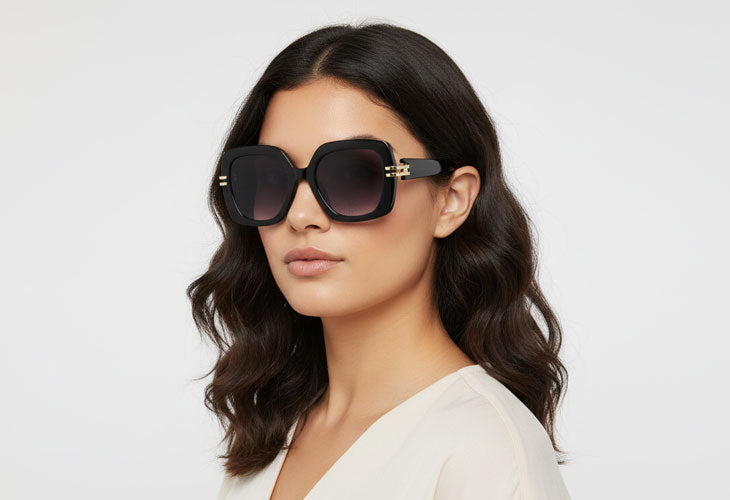 Woman wearing large sunglasses with a plain background