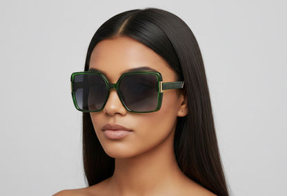 Woman wearing large green sunglasses against a plain background