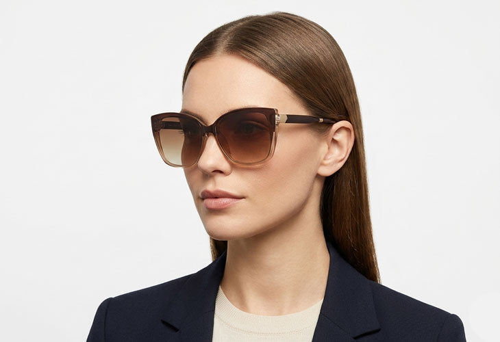 Woman in studio wearing brown cat eye style sunglasses