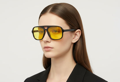 Woman wearing a pair of sunglasses with yellow lenses on a light gray background